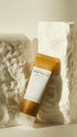 Tube of Centella Asiatica cream on a textured stone background